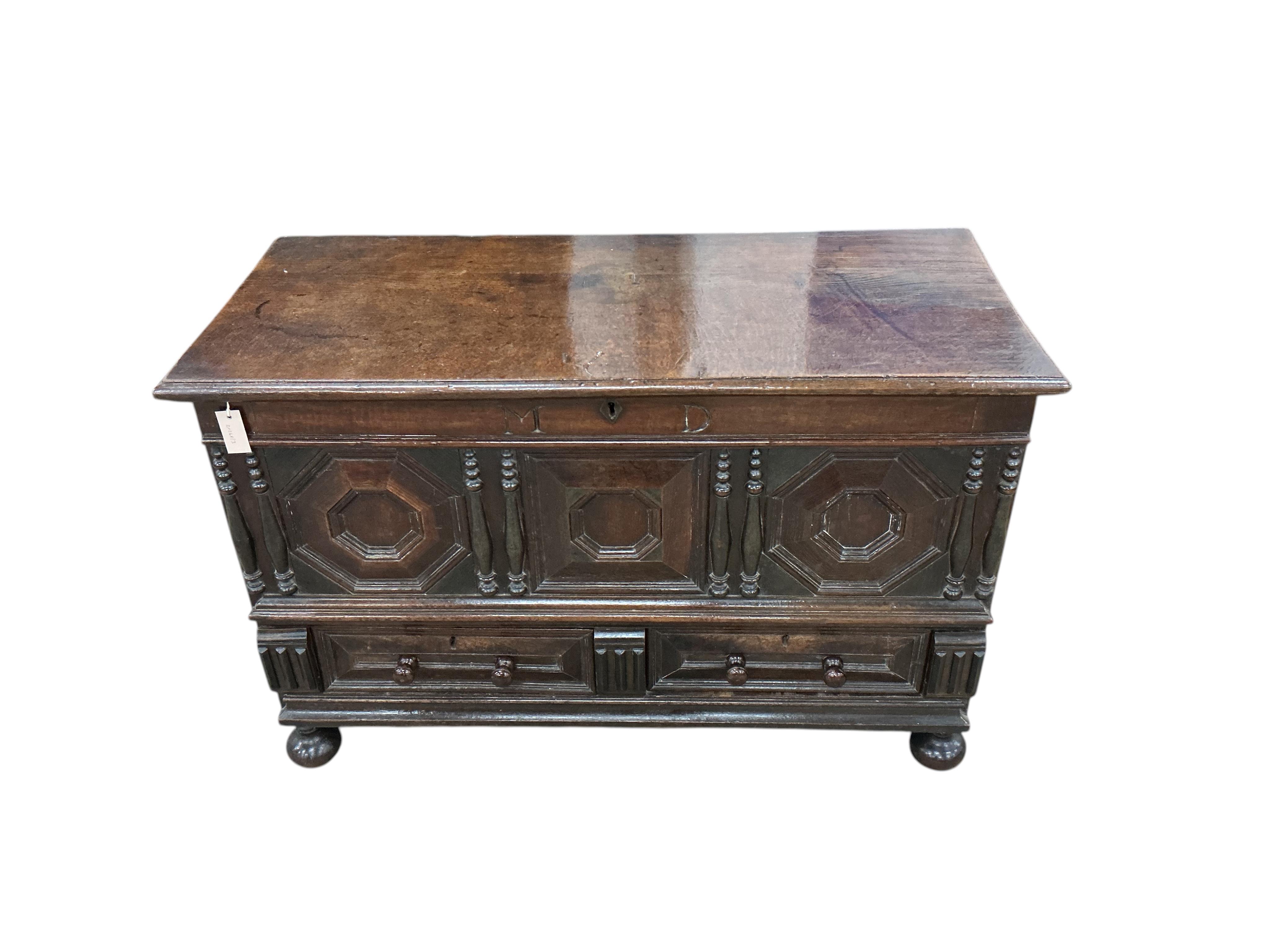 An 18th century panelled oak mule chest, carved with the initials M D, width 129cm, depth 57cm, height 83cm